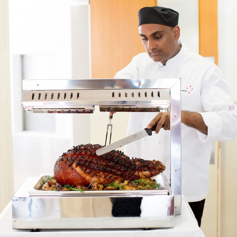 chef carving roast meat for catering industries